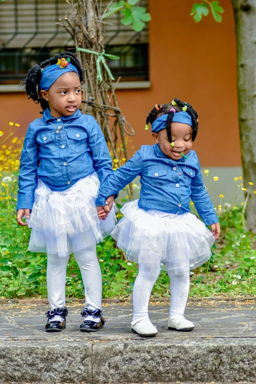 a couple of little girls standing next to each other, an album cover, by Chinwe Chukwuogo-Roy, pexels contest winner, happening, adult pair of twins, walking down, denim, wearing a tutu