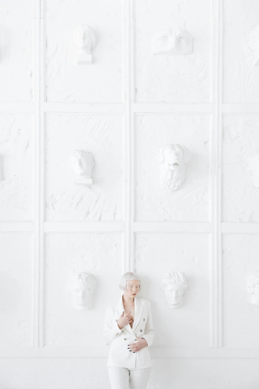 a woman sitting in front of a white wall, a marble sculpture, unsplash, ffffound, die antwoord, rococo details, white wall background