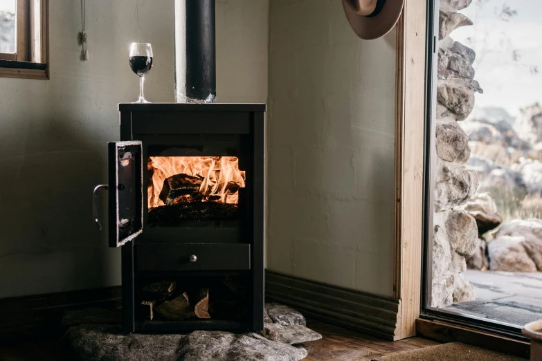 a wood burning stove in the corner of a room, by Lee Loughridge, unsplash contest winner, renaissance, wine, full body length, with clear glass, winter setting