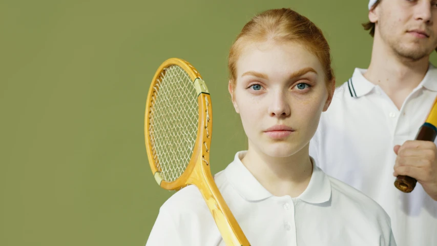 a woman holding a tennis racquet next to a man, inspired by Christoffer Wilhelm Eckersberg, trending on pexels, fantastic realism, sadie sink, white uniform, portrait shot 8 k, large eyebrows