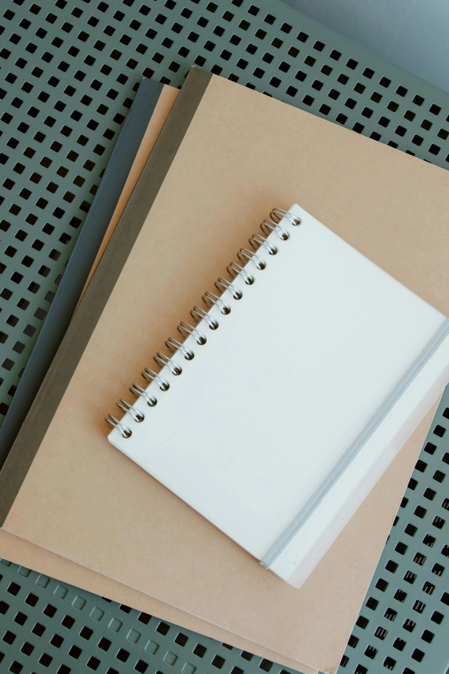 a stack of notebooks sitting on top of a table, by Harvey Quaytman, unsplash, featuring rhodium wires, clipboard, clay material, large screen