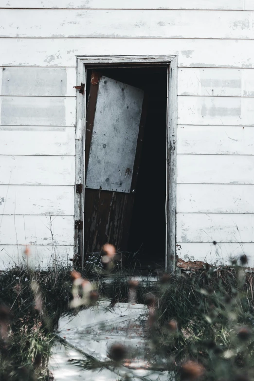 an open door on the side of a white building, pexels contest winner, abandoned cottage, grunge aesthetic, collapsing, profile picture