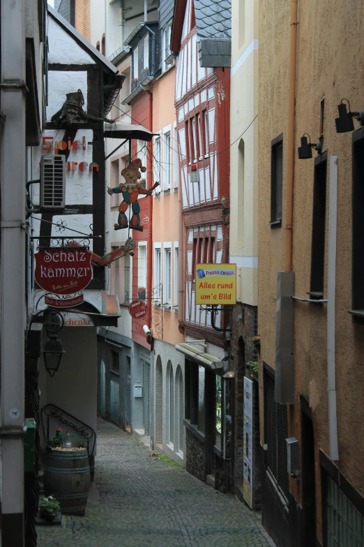 a narrow street in an old european city, flickr, streets of heidelberg, colorful signs, opposite the lift-shaft, gold