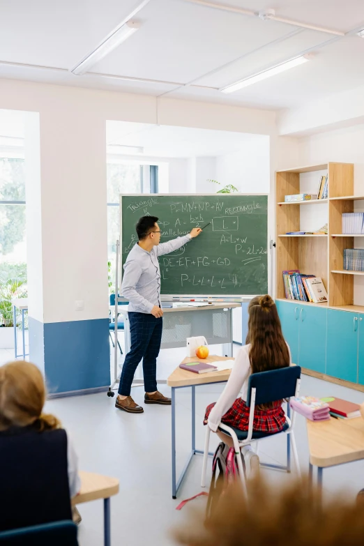a man standing in front of a blackboard in a classroom, trending on unsplash, danube school, 15081959 21121991 01012000 4k
