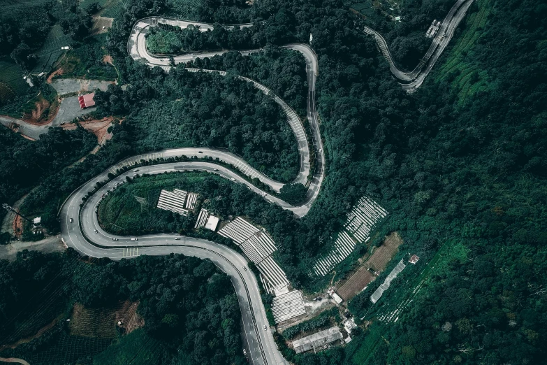 an aerial view of a winding road in the mountains, pexels contest winner, hurufiyya, malaysia jungle, maze of streets, grey, concert