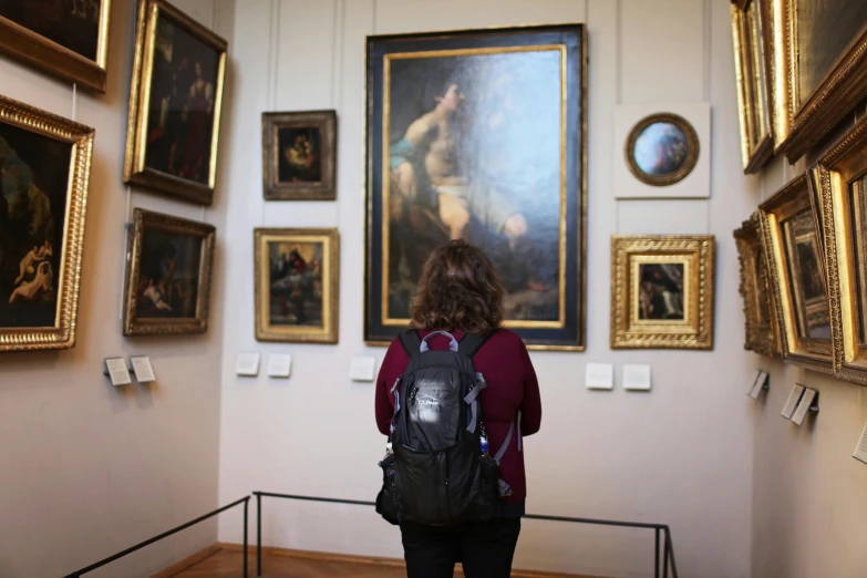 a woman standing in a museum looking at paintings, a painting, inspired by Francesco Hayez, pexels contest winner, academic art, photo still of behind view, bouguereau. full-shot, high quality picture, van dyck