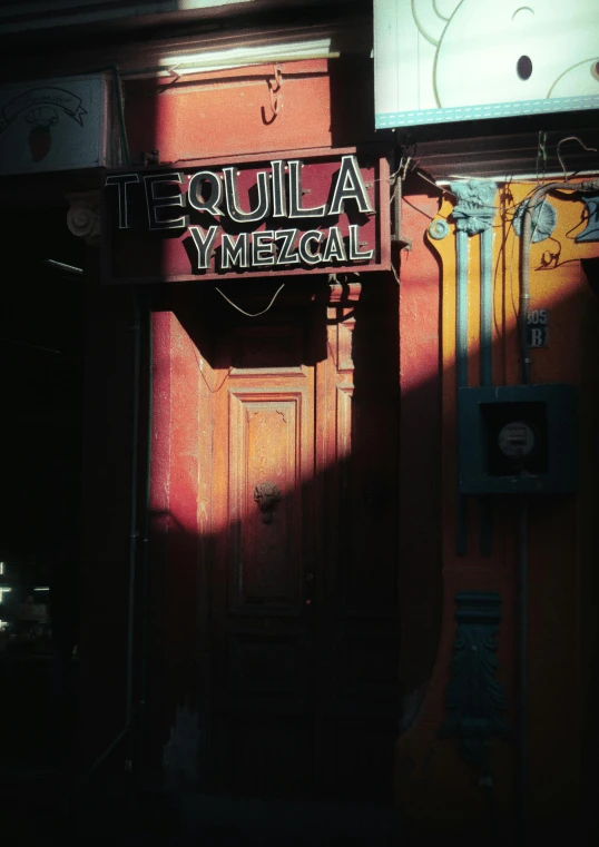 a clock that is on the side of a building, an album cover, inspired by Elsa Bleda, pexels contest winner, standing in a cantina, booze, mexico city, doorway