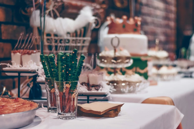 a table topped with lots of food next to a brick wall, a picture, pexels, arts and crafts movement, profile image, cakes, copper and emerald, festive atmosphere