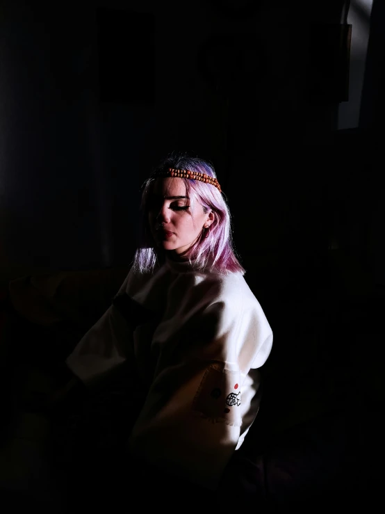 a woman with purple hair sitting in a dark room, inspired by Elsa Bleda, wearing a headband, profile image, androgynous person, meditation