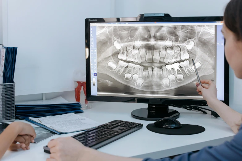 a couple of people sitting at a desk in front of a computer, teeth filled with cavities, medical photography, ultrawide, 3 d software