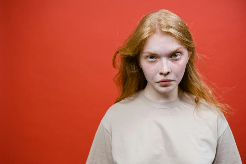 a woman standing in front of a red wall, trending on pexels, hyperrealism, intense albino, male teenager, bruised face, girl in studio