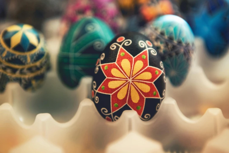 a bunch of eggs that are in a carton, by Adam Marczyński, pexels contest winner, arts and crafts movement, decorated with russian motifs, avatar image, blurred, beautiful black blue yellow