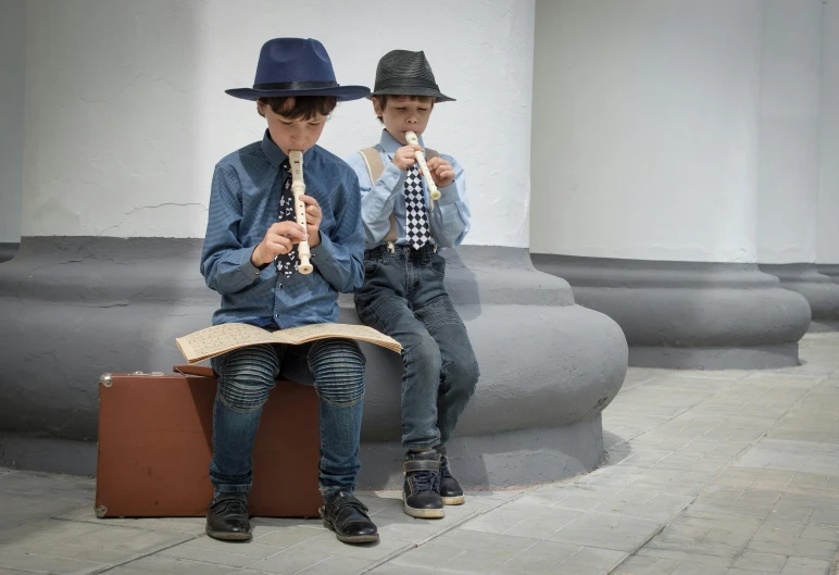 two boys sitting next to each other on a bench, inspired by Joseph Beuys, pexels contest winner, quito school, young girl playing flute, blue fedora, concert, nikolay georgiev