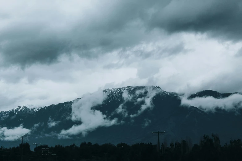 there is a plane that is flying in the sky, by Carey Morris, pexels contest winner, ominous! landscape of north bend, background image, grey, with snow on its peak