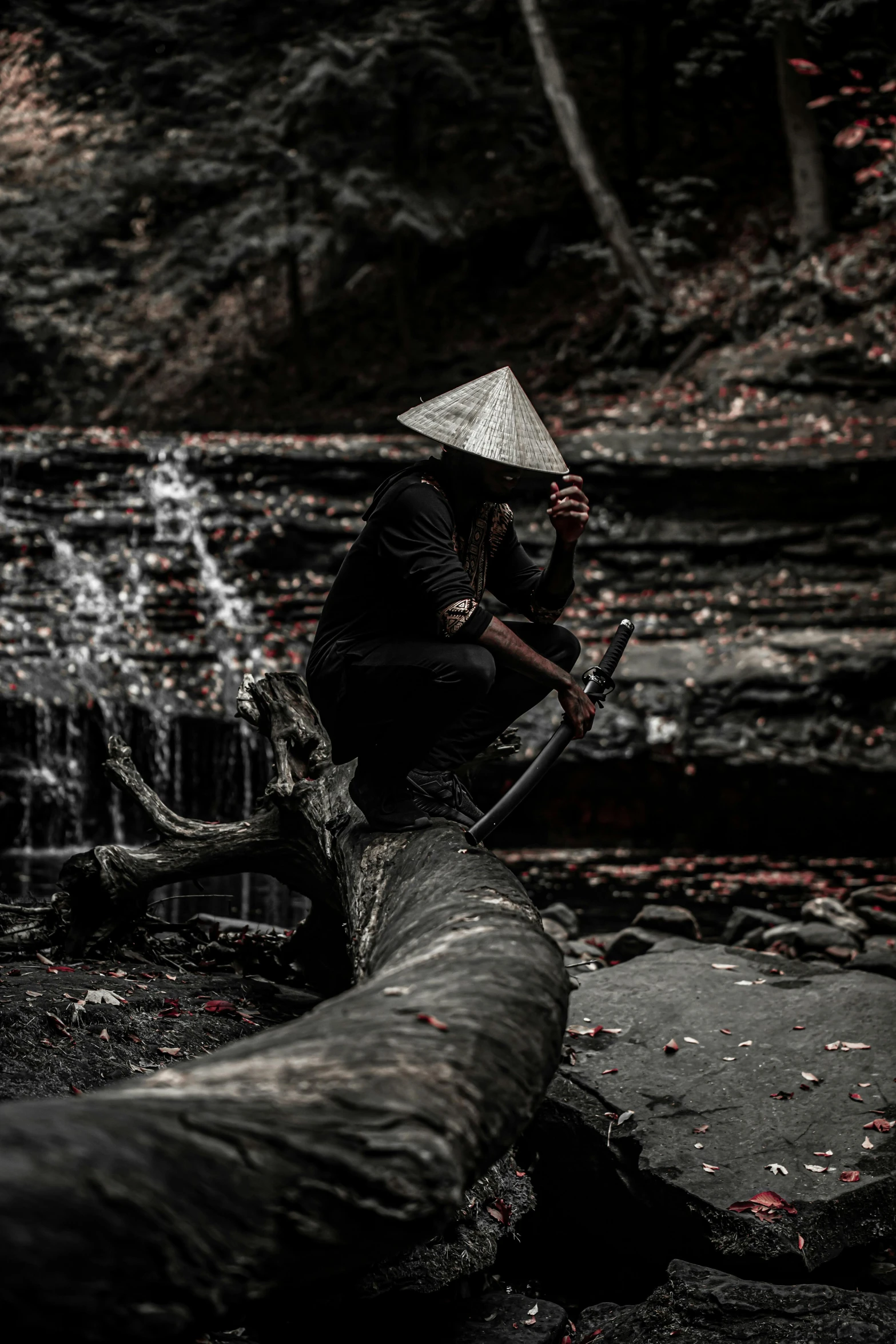 a person sitting on top of a fallen tree, inspired by Fu Baoshi, unsplash contest winner, sumatraism, black pointed hat, thirst, hood, fishing