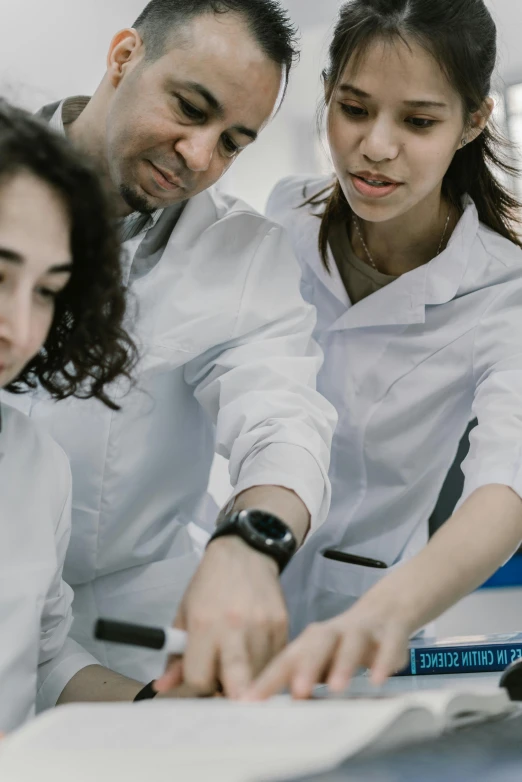 a group of people looking at a computer screen, pexels contest winner, academic art, wearing lab coat and a blouse, avatar image, mechanics, language