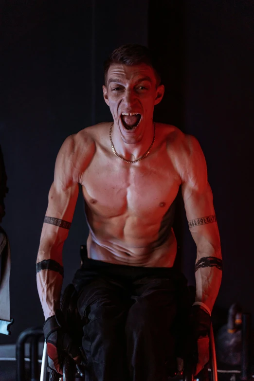 a shirtless man sitting in a wheel chair, antipodeans, very excited, bisexual lighting, in a menacing pose, scene from starship