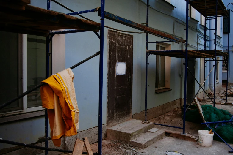 a couple of scaffolding on the side of a building, a photo, by Attila Meszlenyi, arbeitsrat für kunst, blue tunic and robes, in the backrooms, promo image, interior of a small room