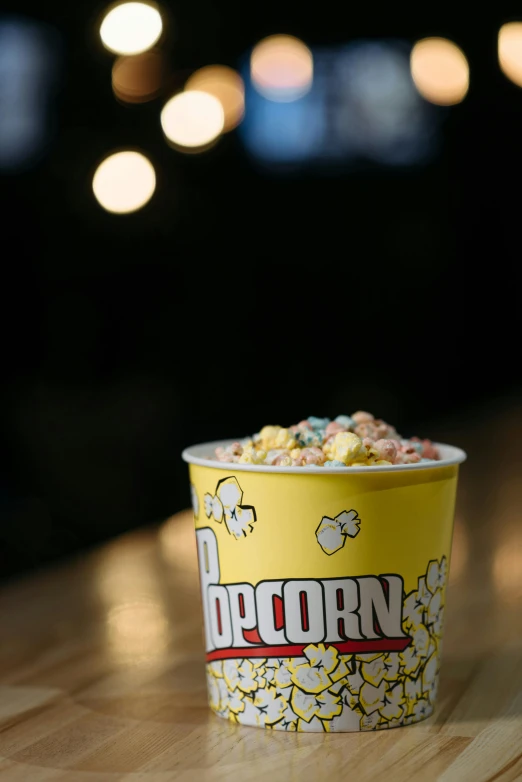 a popcorn cup sitting on top of a wooden table, sea of parfait, detailed product image, multi chromatic, d-cup