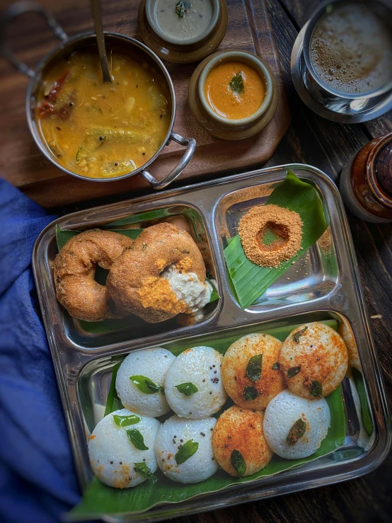 a tray of food sitting on top of a wooden table, inspired by Thota Vaikuntham, unsplash, hurufiyya, high quality product image”