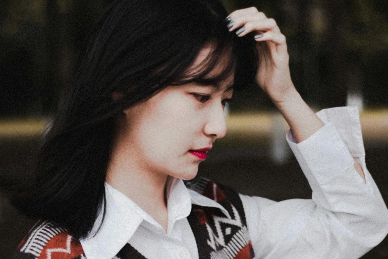 a close up of a person wearing a sweater vest, inspired by Kim Jeong-hui, trending on pexels, realism, hair blackbangs hair, thinking pose, korean woman, scratches on photo