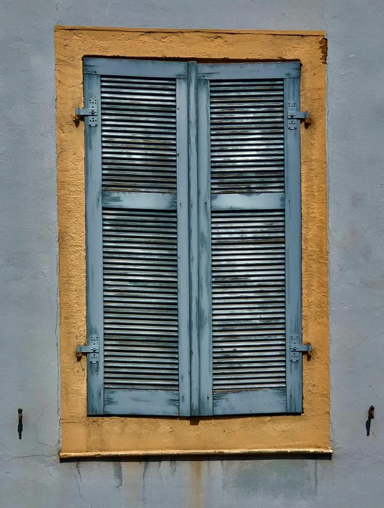 a blue and yellow window on the side of a building, inspired by Gustave Boulanger, pexels contest winner, grey, shutters, silver and muted colors, burnt umber and blue