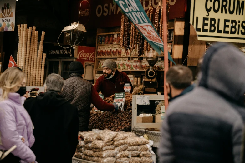 a group of people standing in front of a store, by Tobias Stimmer, pexels contest winner, hurufiyya, food stall, brown, turkey, avatar image