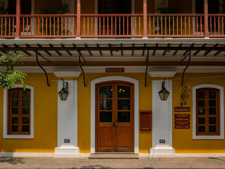 a red fire hydrant sitting in front of a yellow building, bengal school of art, symmetrical doorway, restaurant, brown, colombian