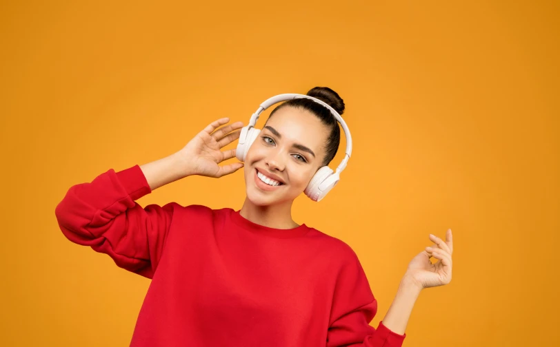 a woman in a red sweater is listening to headphones, trending on pexels, orange and white color scheme, happily smiling at the camera, whealan, halo over her head