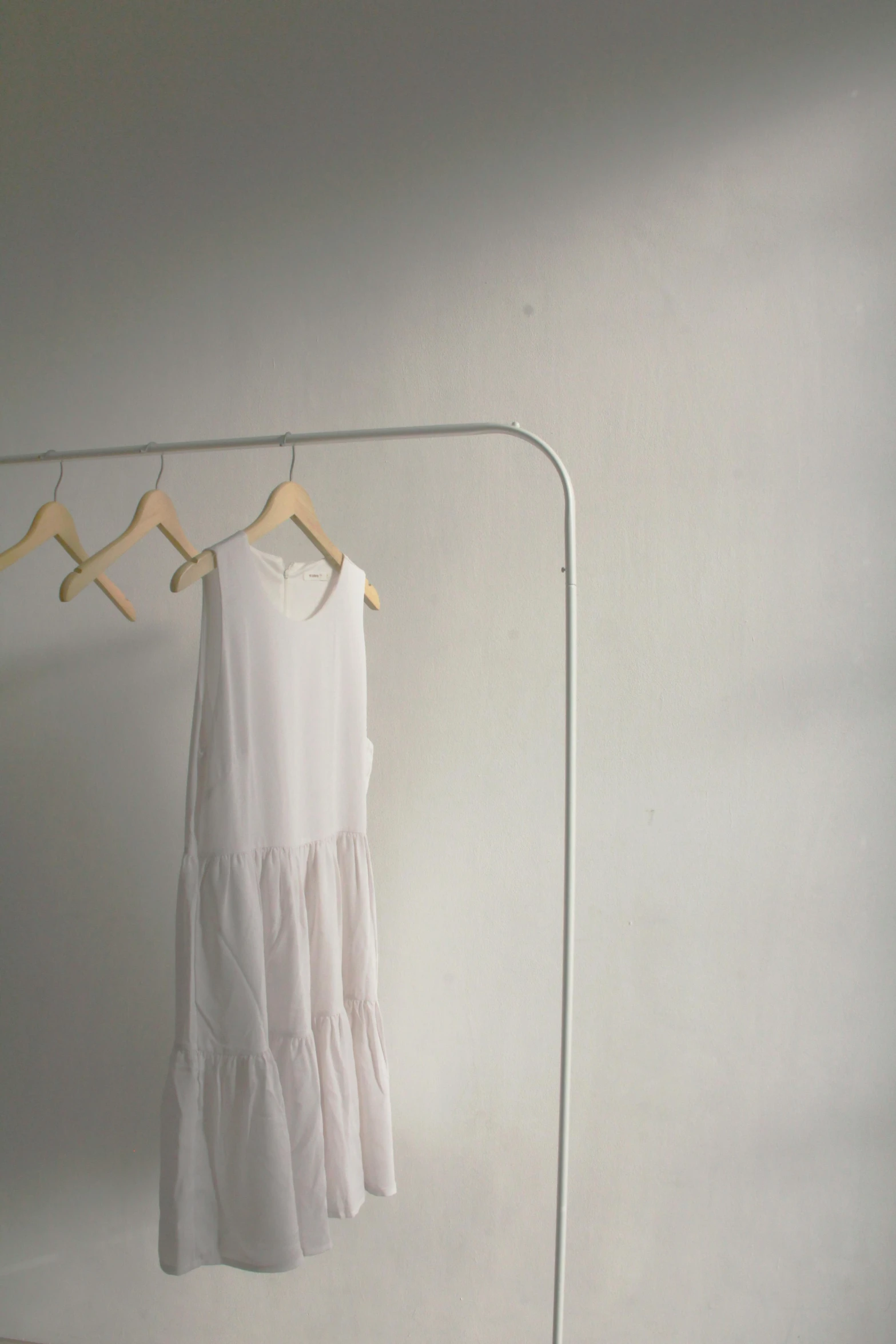 a white dress hanging on a clothes rack, unsplash, postminimalism, modern studio light soft colour, soft light - n 9, real image, vivid)