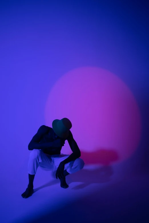 a man sitting on a skateboard in front of a pink ball, by Doug Ohlson, unsplash, conceptual art, blue and purple lighting, masked person in corner, showstudio, crouching