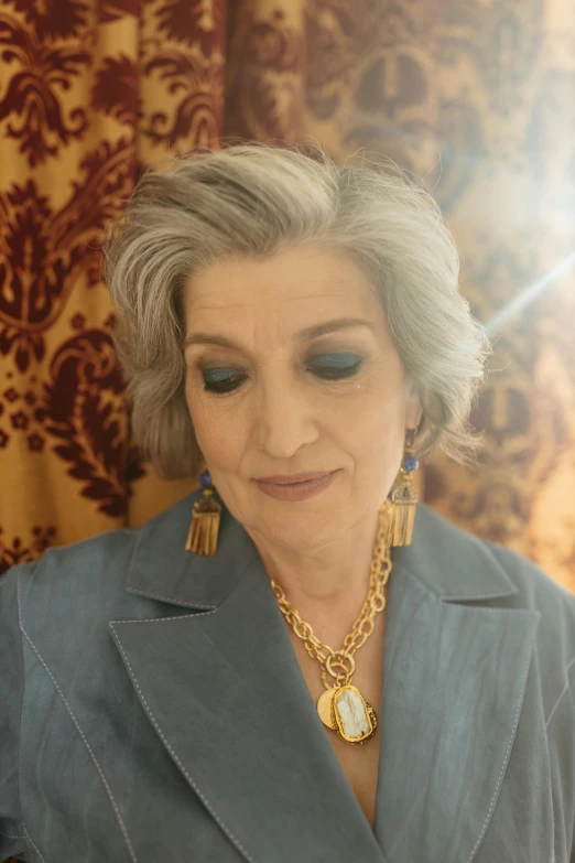a woman that is standing in front of a mirror, an album cover, grey hair, wearing ornate earrings, mirka andolfo, wearing a blue jacket