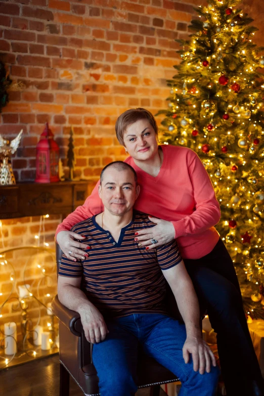 a man and woman sitting in front of a christmas tree, home photography portrait, rostov, warmly lit, soft