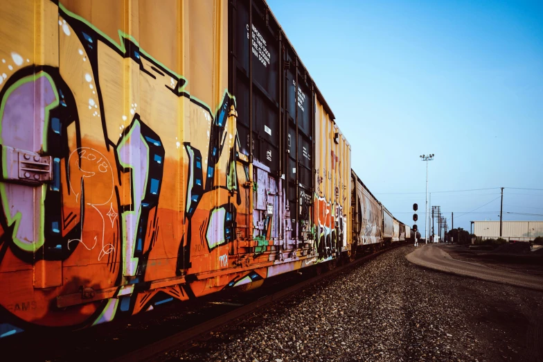 a train with graffiti on the side of it, pexels contest winner, shipping containers, trending on vsco, wide long view, 🚿🗝📝