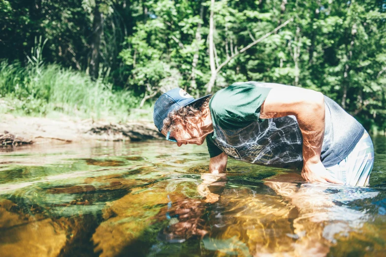 a man that is standing in some water, by Emma Andijewska, pexels contest winner, peacefully drinking river water, avatar image, small mouth, thumbnail