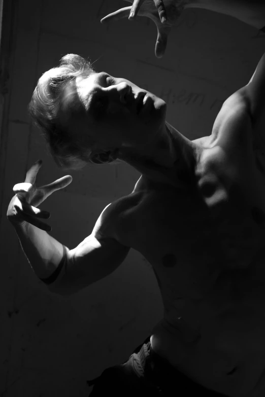 a black and white photo of a man holding scissors, a statue, inspired by Dmitry Levitzky, art photography, flexing, beth cavener, ((((volumetric lighting)))), dancer