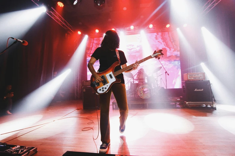 a person standing on a stage with a guitar, pexels contest winner, teenage engineering moad, vaughan bass, temples, stoner rock