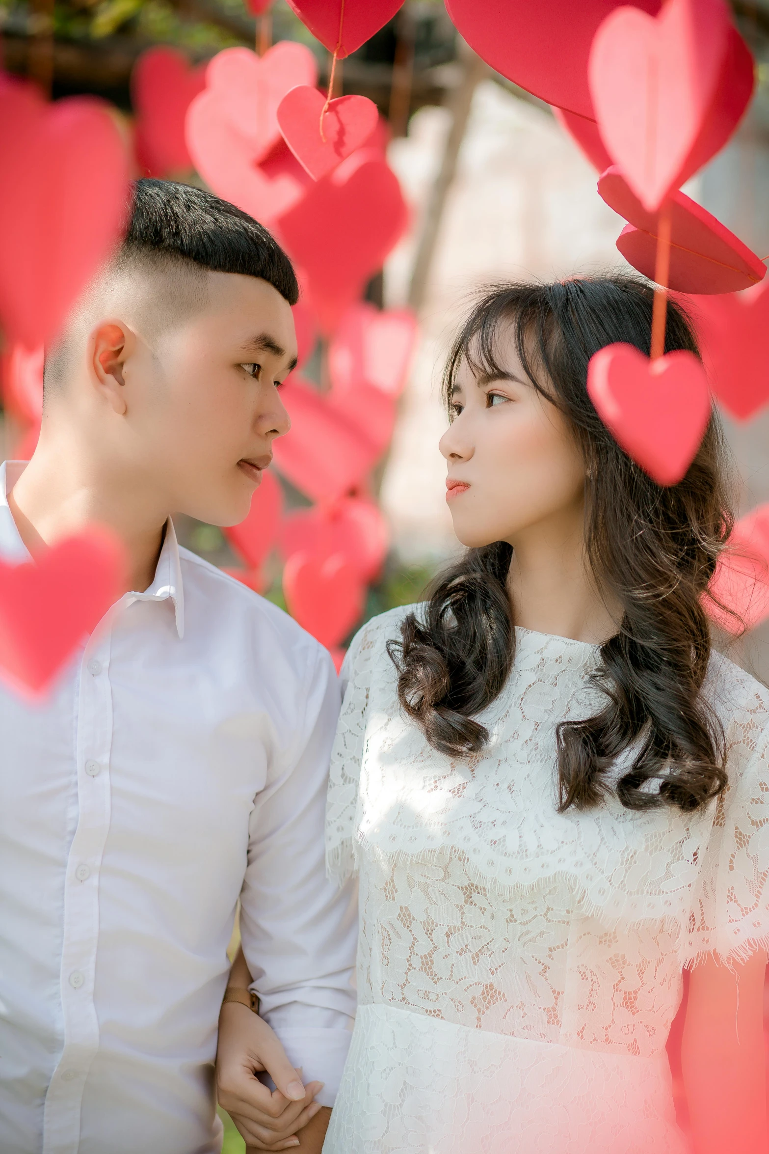 a man and a woman standing next to each other, pexels contest winner, red hearts, ao dai, square, 15081959 21121991 01012000 4k