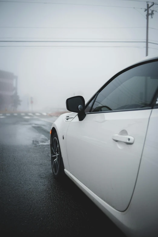a white car parked on the side of the road, foggy weather, low profile, high-quality photo, mid body shot
