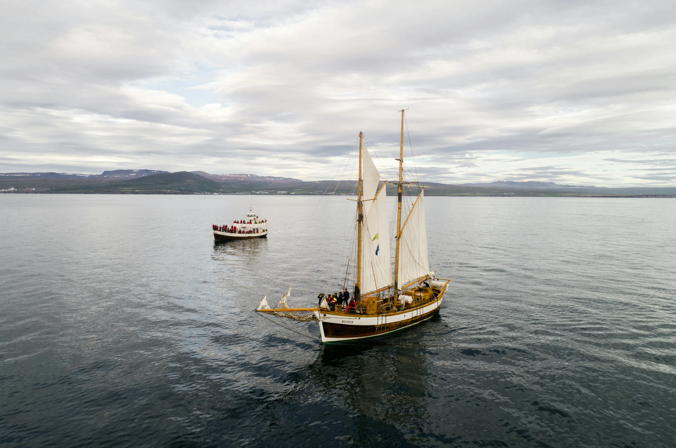 a couple of boats floating on top of a body of water, by Ejnar Nielsen, pexels contest winner, hurufiyya, battle of cape ecnomus, lachlan bailey, family friendly, he's on an old sailing boat