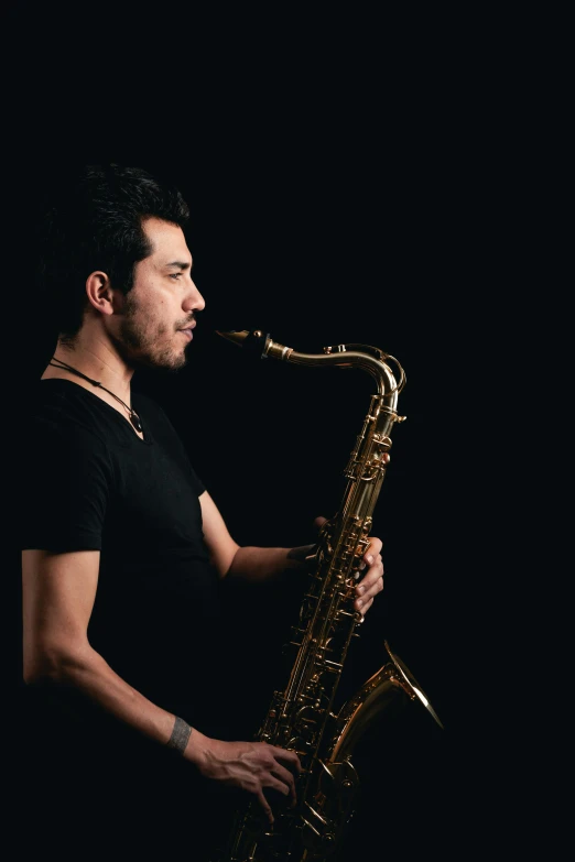 a man playing a saxophone against a black background, by Niko Henrichon, young spanish man, profile pic, promo image, uploaded