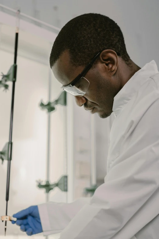 a man in a white lab coat and blue gloves, inspired by Afewerk Tekle, unsplash, panel, profile, plating, wearing lab coat and glasses