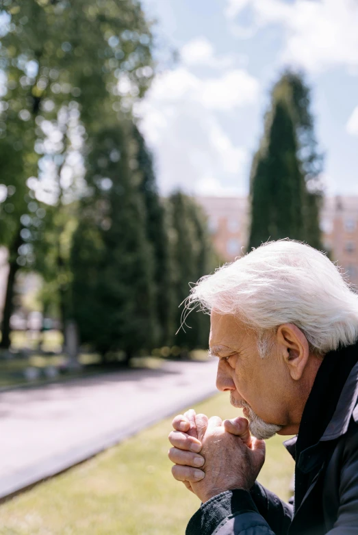 an older man sitting on a bench in a park, unsplash, photorealism, coughing, in sunny weather, pray, white-haired