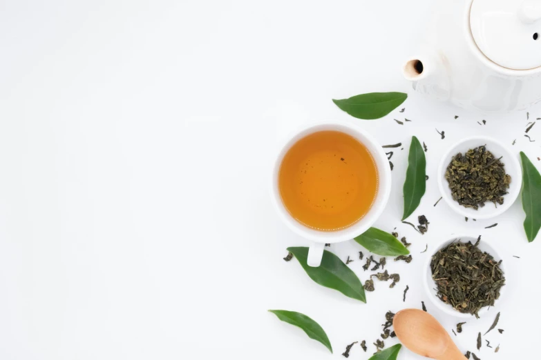 a white tea pot sitting on top of a white table, product image, food, banner, green