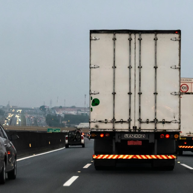 a white truck driving down a highway next to a car, tail lights, 15081959 21121991 01012000 4k, square, grey