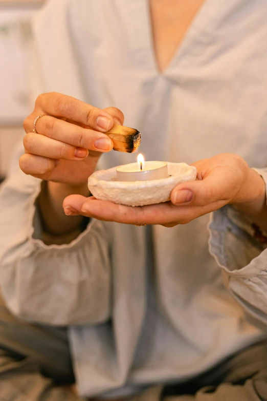 a woman holding a lit candle in her hands, a marble sculpture, inspired by Modest Urgell, renaissance, tea ceremony scene, natural materials, instagram post, health spa and meditation center