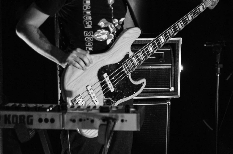 a black and white photo of a man playing a bass guitar, by Dave Melvin, pexels, mastodonic, bass sound waves on circuitry, bass wood, rectangle