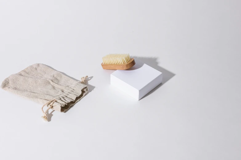 a wooden brush sitting on top of a white box, unsplash, soap, plastic and fabric, white soft leather model, dezeen