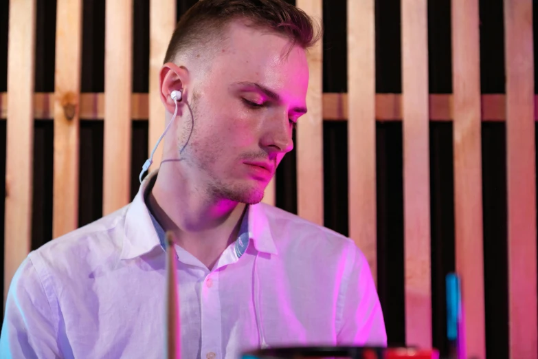 a man in a white shirt is playing drums, an album cover, unsplash, realism, pink headphones, flume cover art, profile picture 1024px, in a nightclub