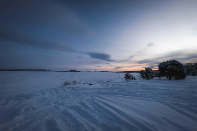 a snow covered field with trees in the distance, a picture, inspired by Eero Järnefelt, unsplash contest winner, hurufiyya, wide river and lake, dusk sky, white desert, lakes